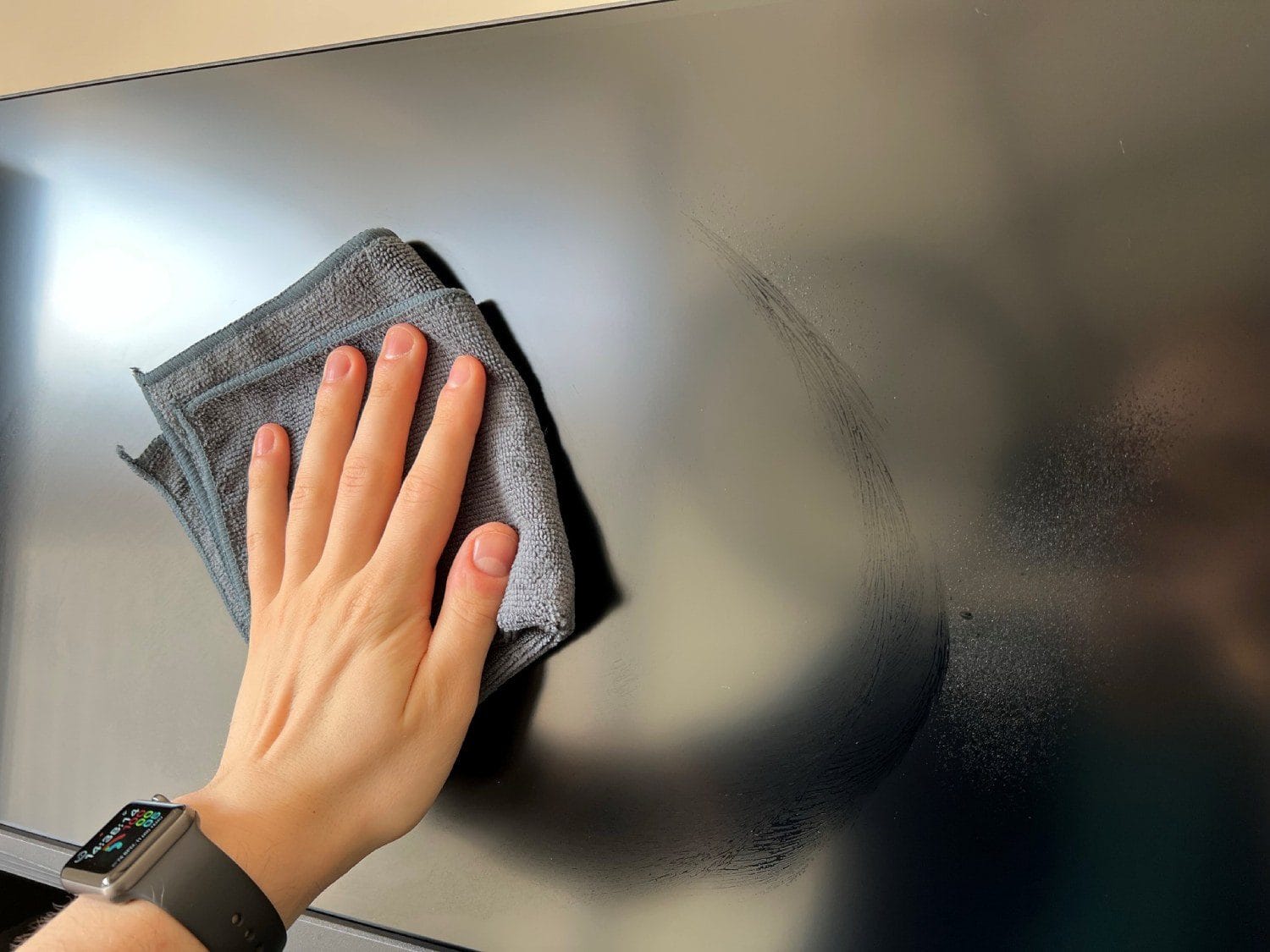 Zakurzony ekran telewizora lub monitora z widocznym lepiącym się osadem, symbolizującym film glicerynowy przyciągający kurz.