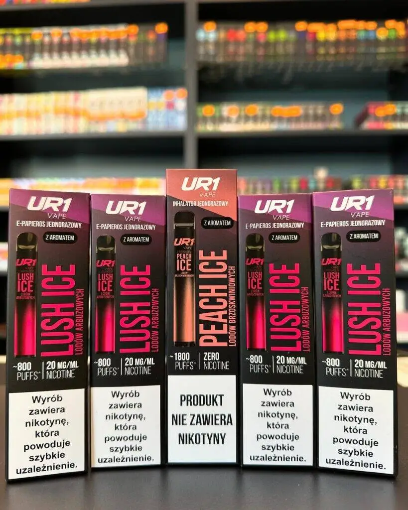 Obok siebie leżące różne typy e-papierosów: mały jednorazowy UR1 Vape 800, większy jednorazowy oraz system pod wielorazowego użytku.