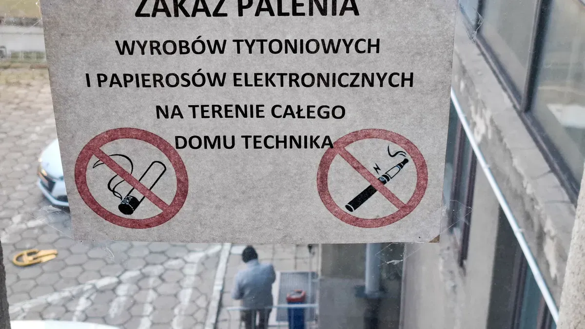 Znak zakazu sprzedaży i importu e-papierosów, z paczką z Chin i e-papierosem w tle, symbolizujący nielegalność transakcji.