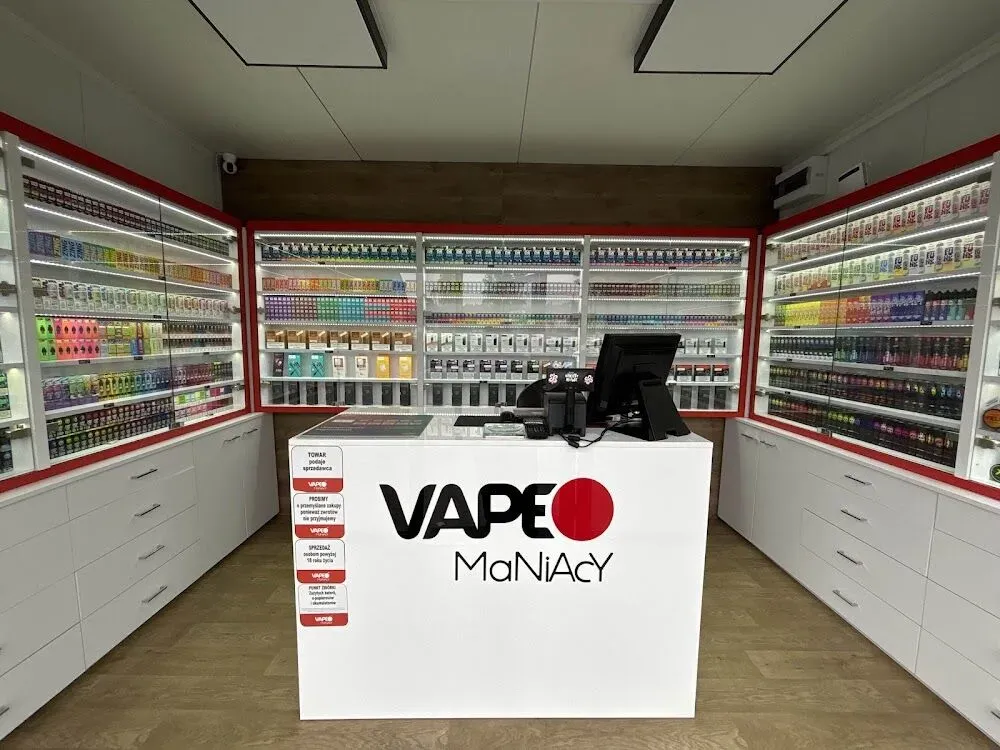 Wnętrze nowoczesnego vape shopu z ekspozycją legalnych produktów i obsługującym sprzedawcą, podkreślające bezpieczny zakup stacjonarny.