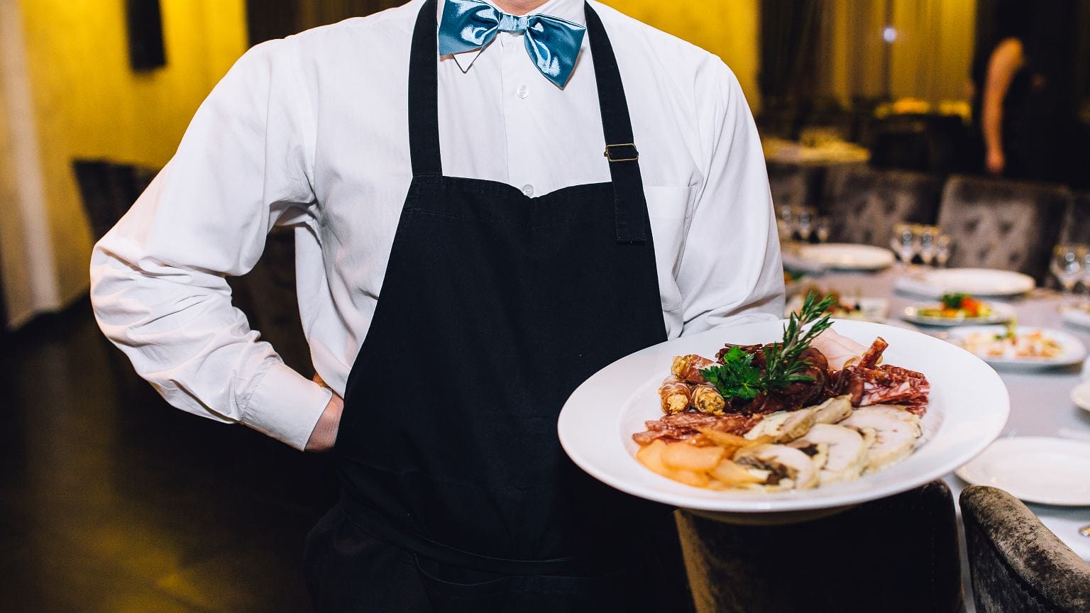 Mężczyzna niegrzecznie zwracający się do kelnera w restauracji podczas randki, pokazując prawdziwą czerwoną flagę w zachowaniu.