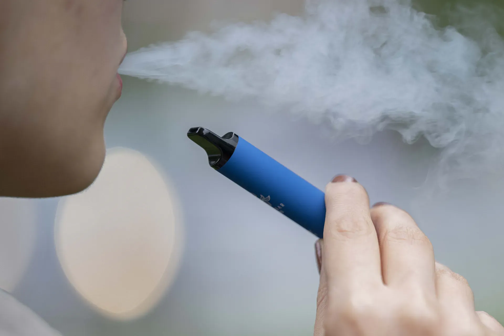 Smutny lub zaniepokojony vaper trzymający e-papierosa, symbolizujący frustrację i niepewność regulacyjną związaną z nadchodzącymi zakazami.